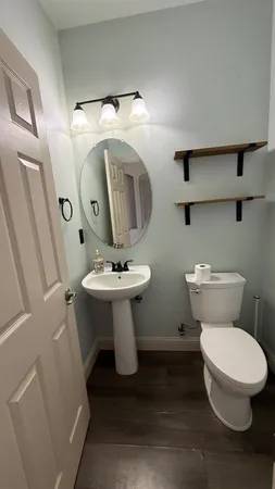 a bathroom with a toilet sink and mirror