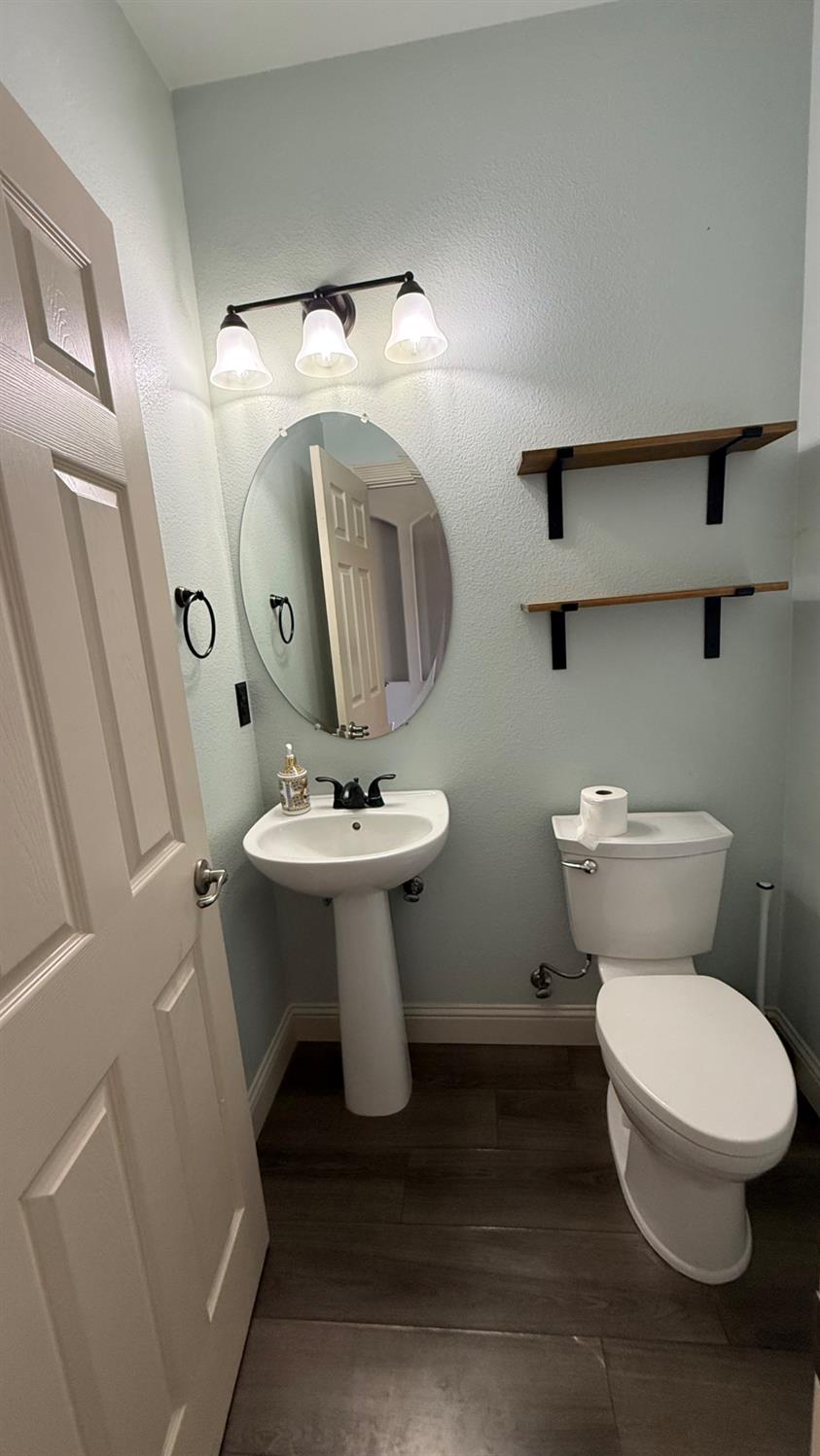 1416 San Rafael Street Los Banos, CA 93635 - Photo 7 of 21 a bathroom with a toilet sink and mirror