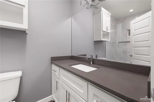 a bathroom with a sink a toilet and a mirror