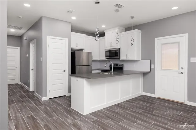 a kitchen with stainless steel appliances a refrigerator sink and microwave