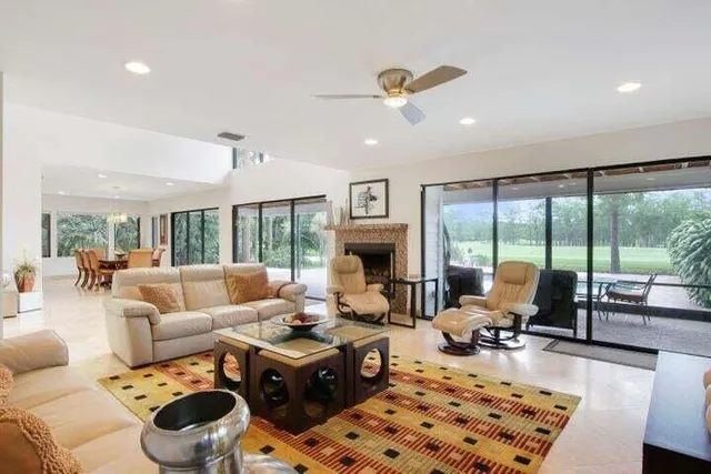 a living room with furniture fireplace and large windows