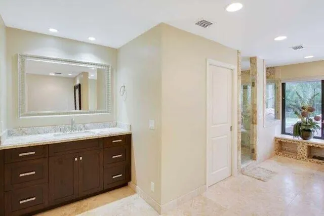 a bathroom with a granite countertop sink mirror and vanity