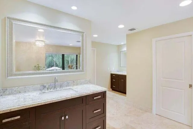 a bathroom with a granite countertop sink mirror and double