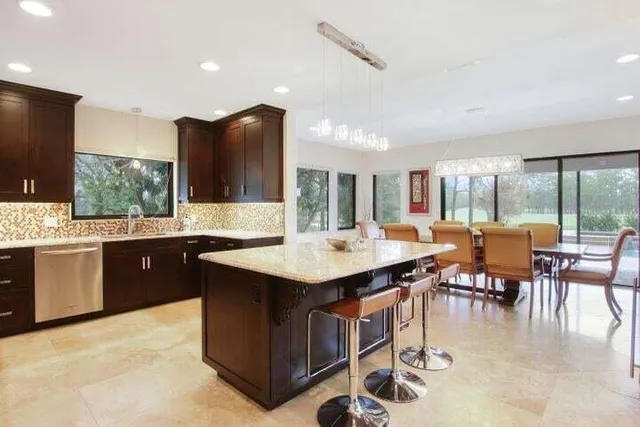 a kitchen with a sink counter top space appliances and a large window