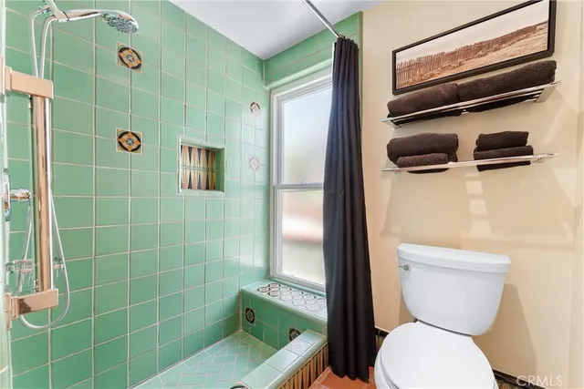 a bathroom with a double vanity sink toilet and a mirror