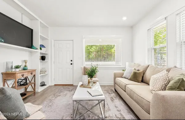 a living room with furniture a flat screen tv and a large window