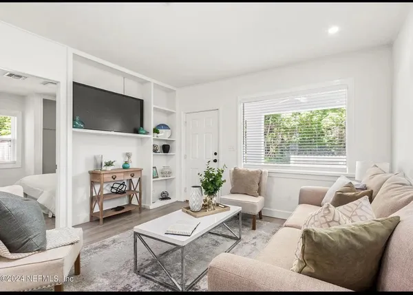 a living room with furniture a flat screen tv and a large window