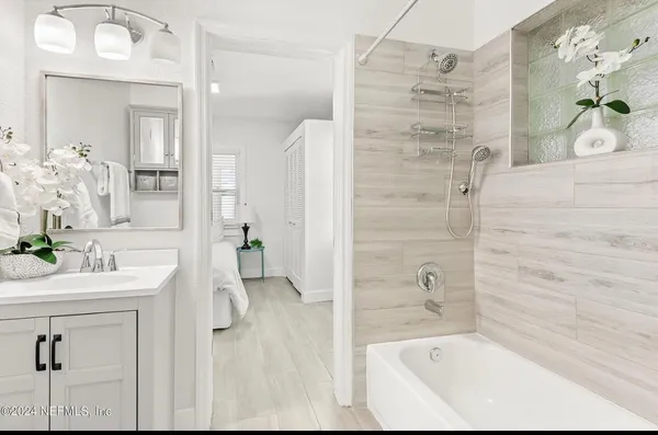 a bathroom with a bathtub sink and mirror