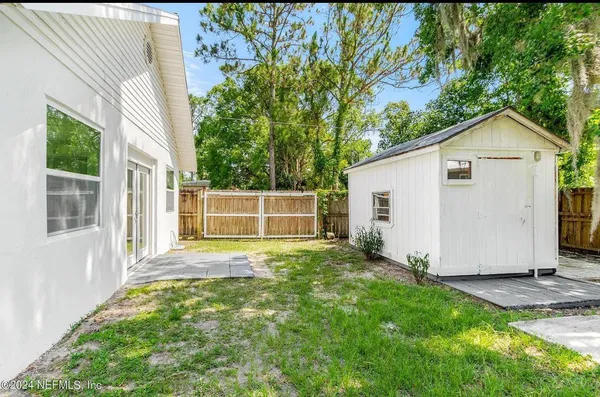 a view of backyard of house with green space