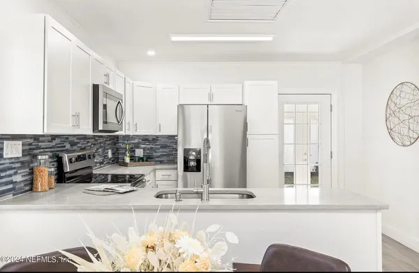 a kitchen with stainless steel appliances granite countertop a sink and a refrigerator