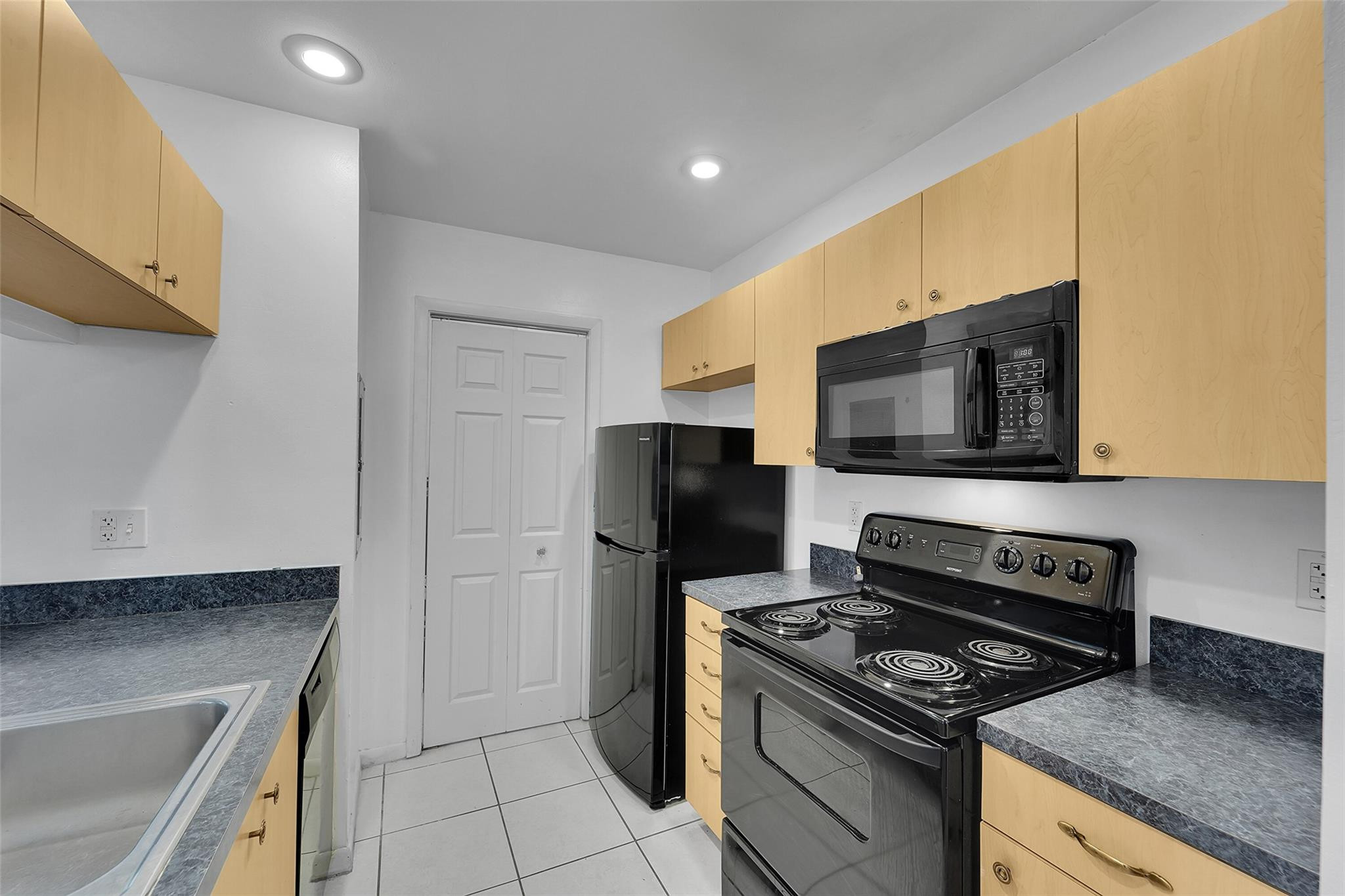 2698 North Nob Hill Road Sunrise, FL 33322 - Photo 5 of 27 a kitchen with a stove and a microwave