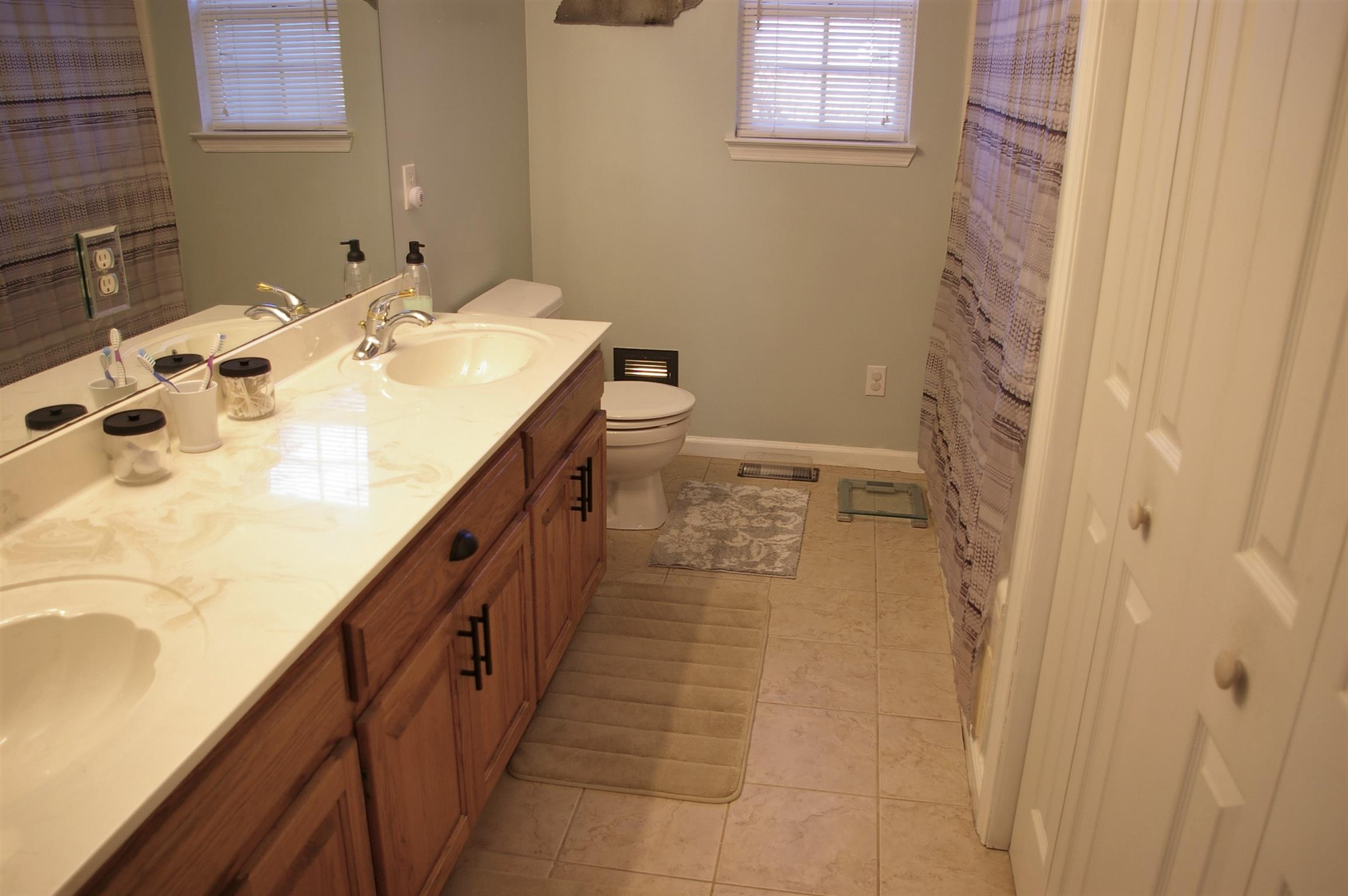 44 Old Pocahontas Road Manchester, TN 37355 - Photo 14 of 20 a bathroom with a double vanity sink a toilet and a shower