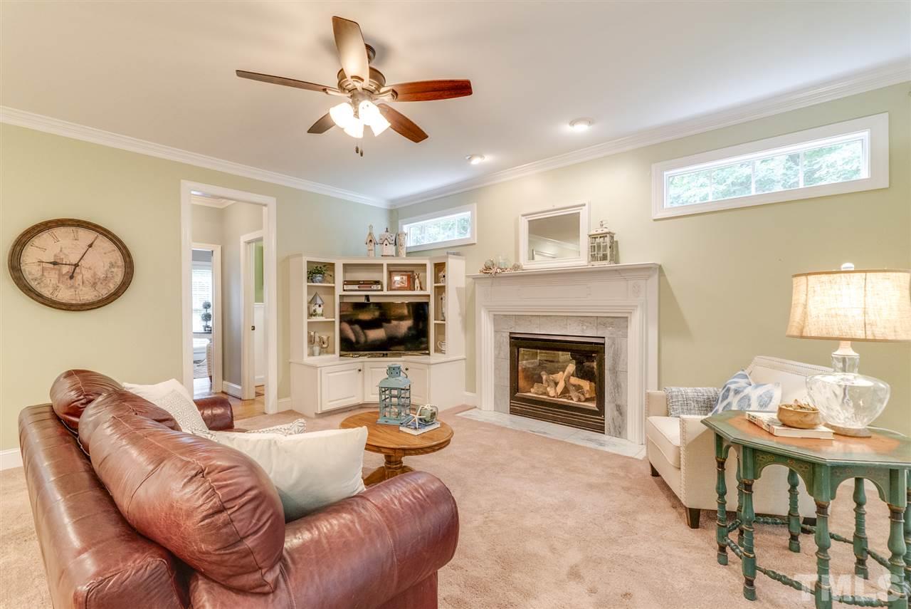 1701 Crown Glenn Place Raleigh, NC 27613 - Photo 11 of 25 a living room with furniture a clock and a fireplace