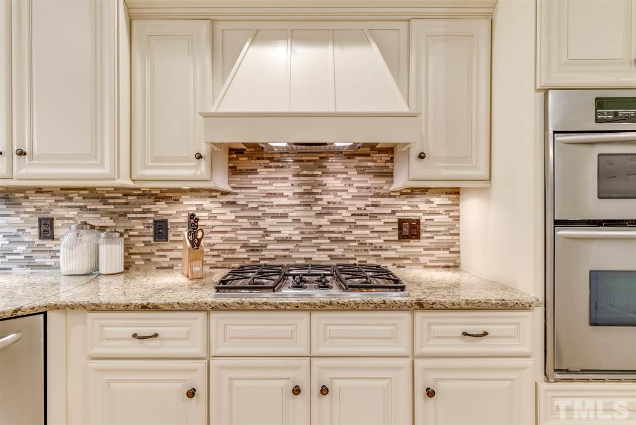 1701 Crown Glenn Place Raleigh, NC 27613 - Photo 15 of 25 a kitchen with granite countertop a sink stove and cabinets