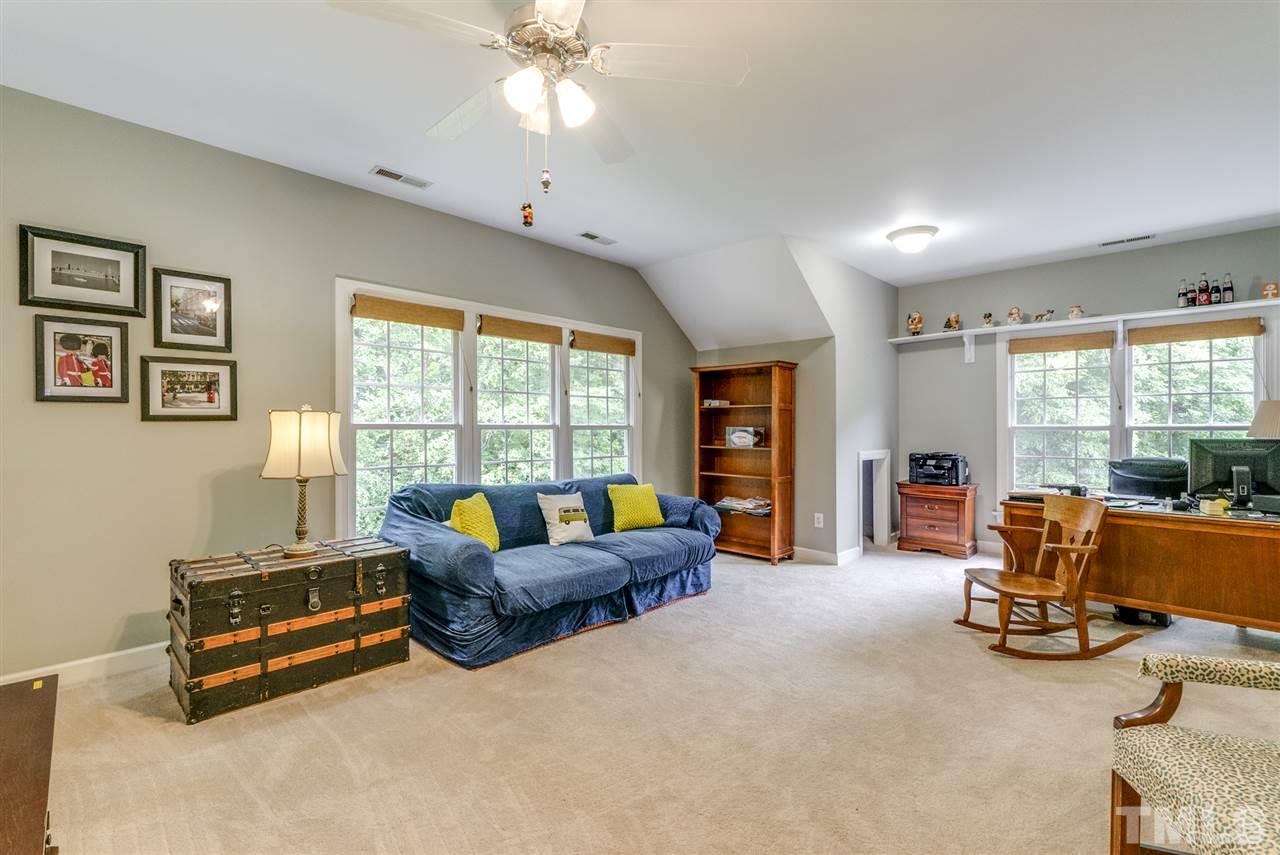 1701 Crown Glenn Place Raleigh, NC 27613 - Photo 23 of 25 a living room with furniture gym equipment and large windows