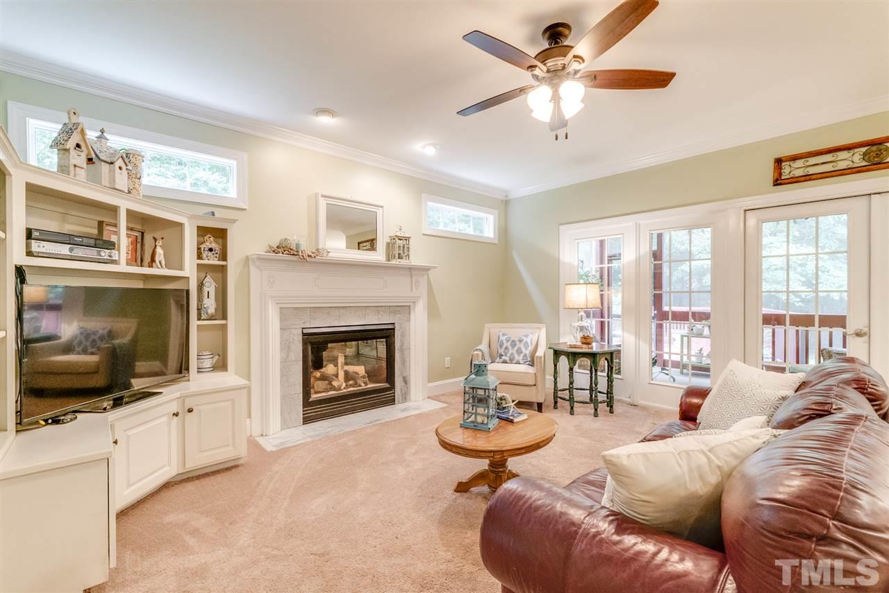 1701 Crown Glenn Place Raleigh, NC 27613 - Photo 10 of 25 a living room with furniture a flat screen tv and a fireplace