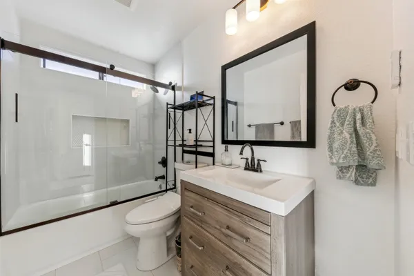 a bathroom with a sink vanity mirror and toilet
