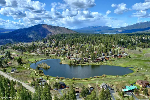 a view of a city with lots of residential buildings ocean and mountain view in back yard