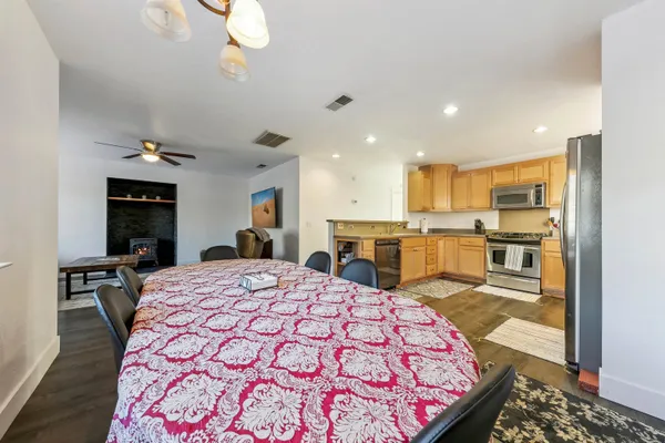 a large kitchen with kitchen island a stove a sink dishwasher and a dining table with wooden floor