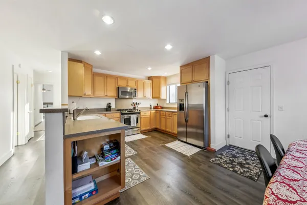 a kitchen with stainless steel appliances granite countertop a refrigerator and a stove top oven