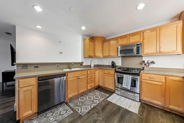 a kitchen with stainless steel appliances granite countertop a stove a sink and a refrigerator