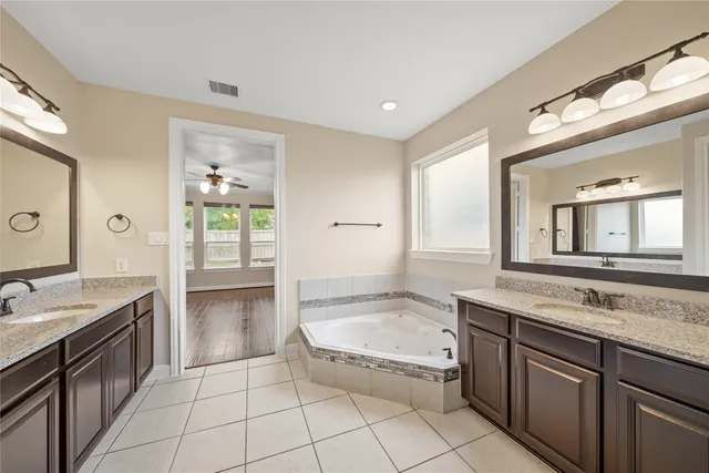 a spacious bathroom with a granite countertop tub sink and mirror