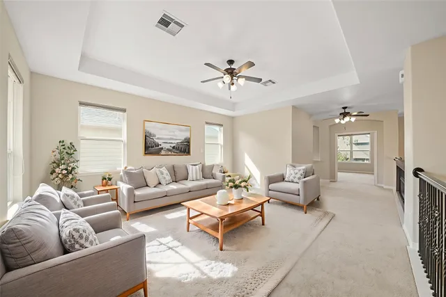 a living room with furniture ceiling fan and a window