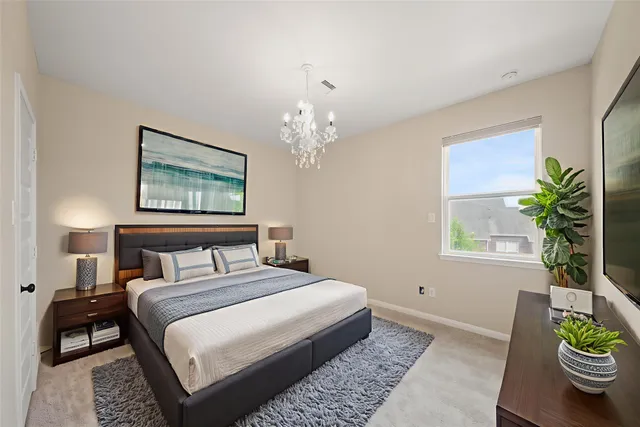 a bedroom with a large bed and a chandelier