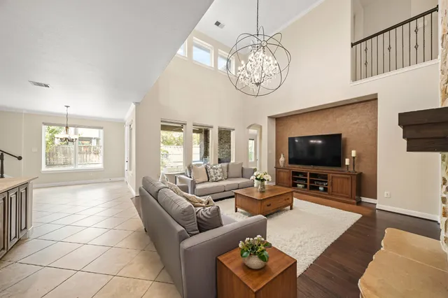 a living room with furniture a flat screen tv and a window