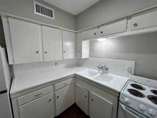 a utility room with cabinets washer and dryer