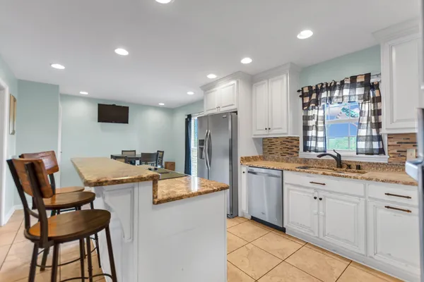a kitchen with a table chairs refrigerator and microwave