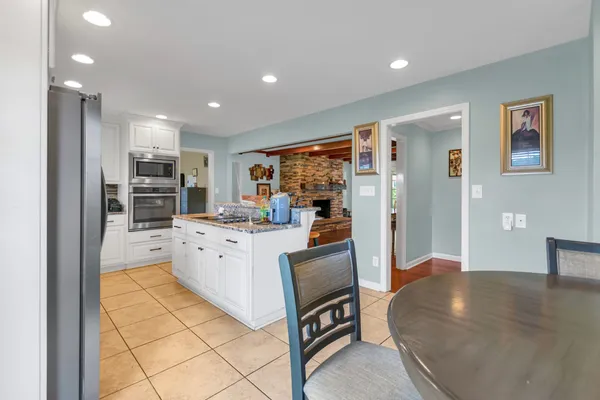 a open kitchen with stainless steel appliances granite countertop a refrigerator and a stove top oven