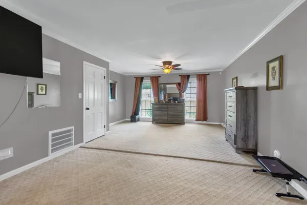 a view of empty room with a kitchen and refrigerator
