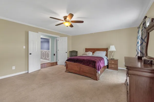 a spacious bedroom with a bed and a chandelier