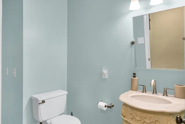 a bathroom with a granite countertop toilet and a sink