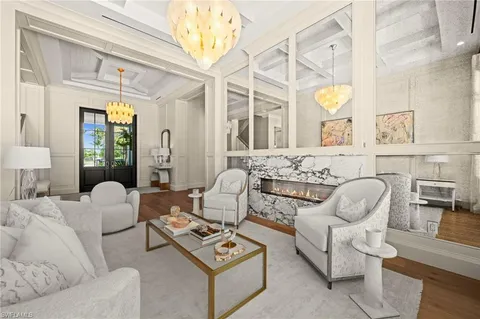 a living room with furniture a chandelier and a fireplace