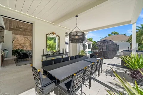 a living room with patio furniture and a large window