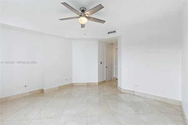 an empty room with closet and a ceiling fan