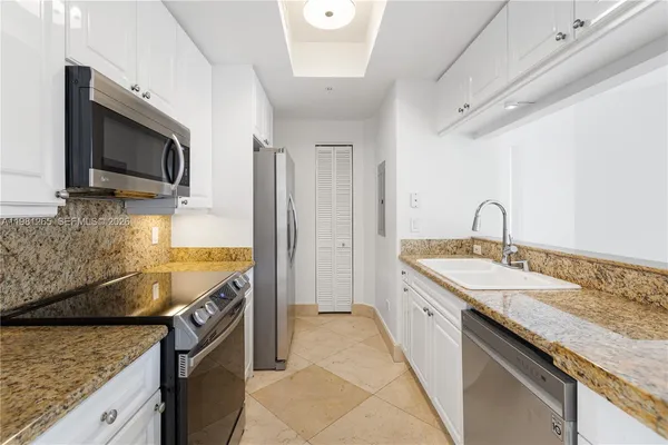 a kitchen with granite countertop a sink and a stove top oven