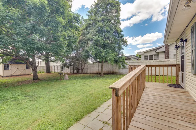 a view of a house with backyard and tree