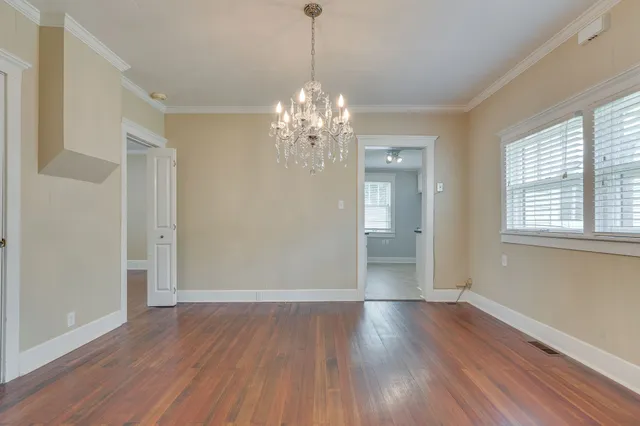 a view of a chandelier in a room with window and wooden floor