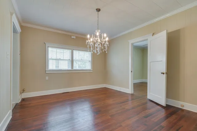 a view of a room with wooden floor and chandelier