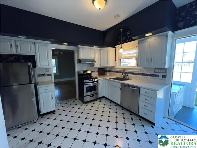 a kitchen with stainless steel appliances a refrigerator and a stove top oven