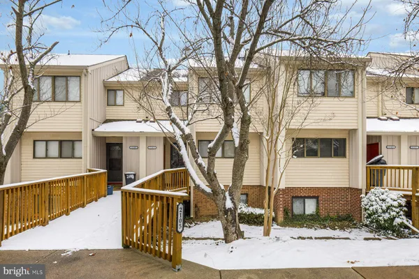 a front view of a house with large tree