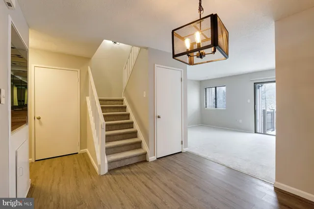 a view of a livingroom with wooden floor and stairs