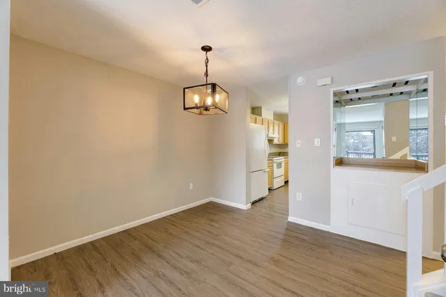 a view of empty room with wooden floor and window