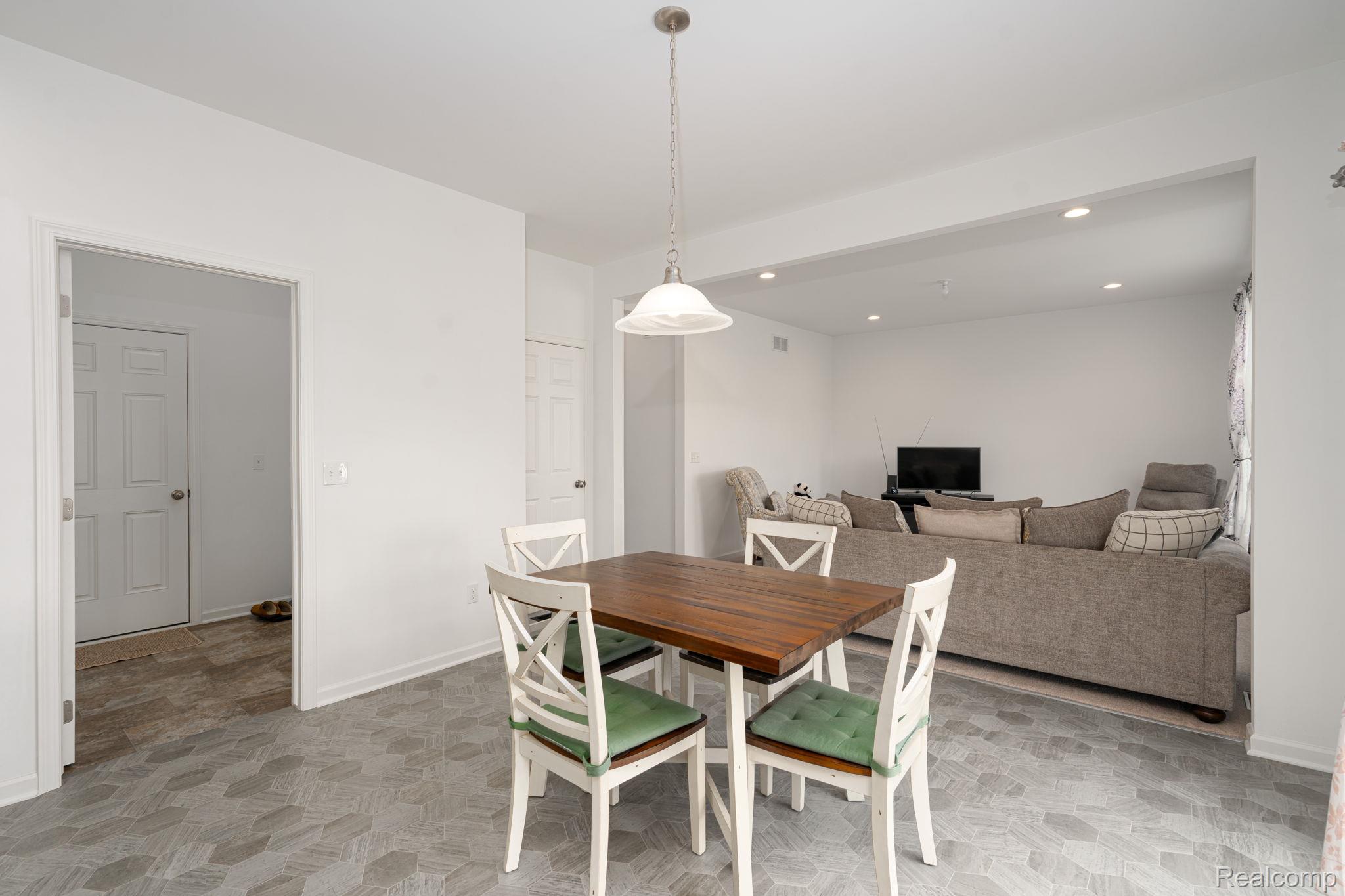 48904 Carnegie Way Macomb, MI 48042 - Photo 13 of 34 Open-concept dining area featuring a pendant light fixture and patterned floor tiling
