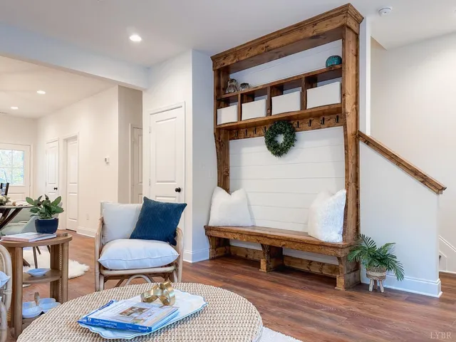 a living room with furniture kitchen view and a wooden floor