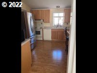 1267 Tucker Road, Unit 8 Hood River, OR 97031 - Photo 10 of 21 a kitchen with stainless steel appliances granite countertop a refrigerator a sink a stove and island