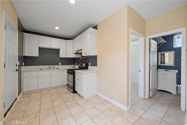 a kitchen with white cabinets a sink and appliances
